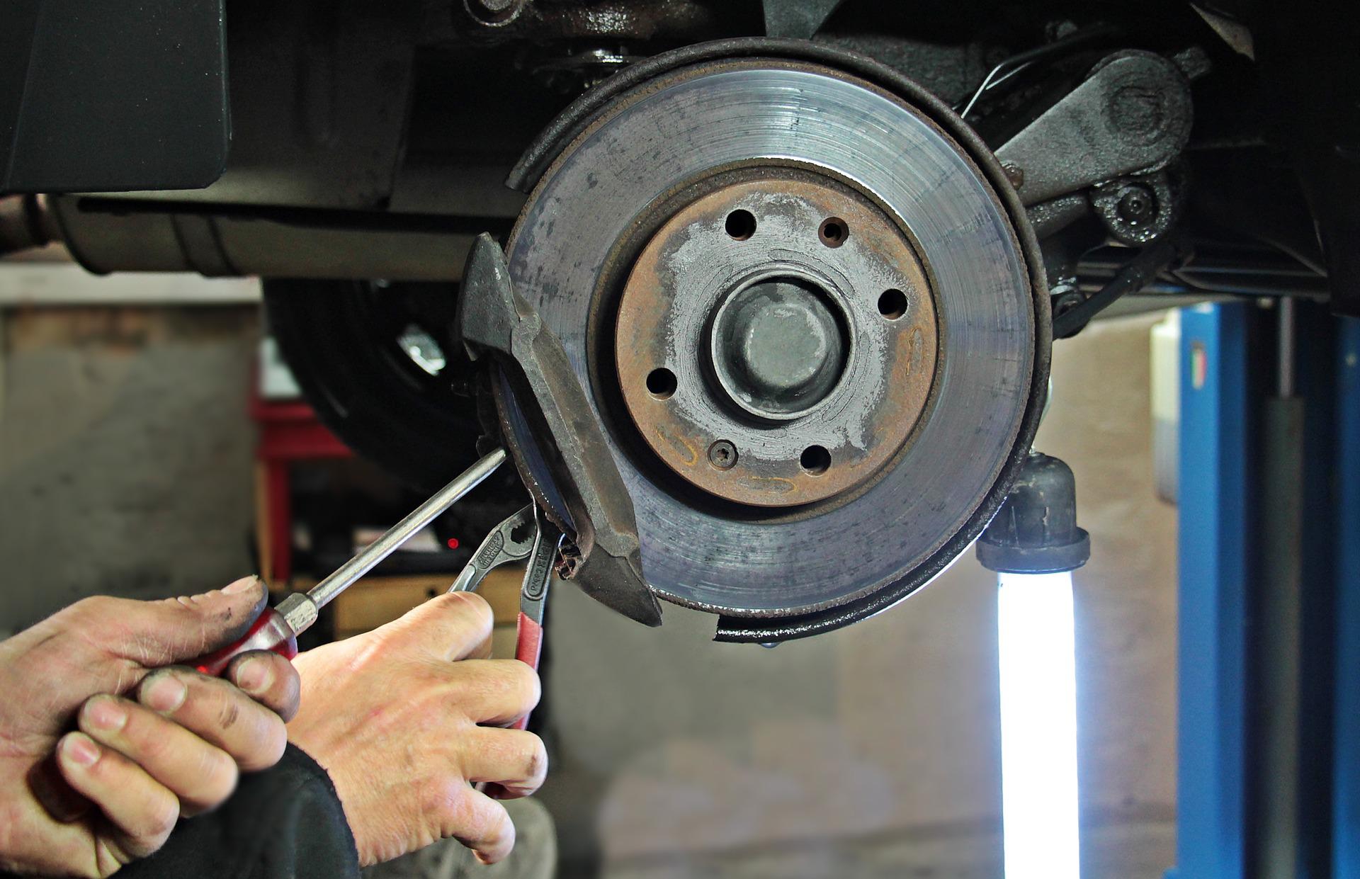 A mechanic working on a vehicle's wheel